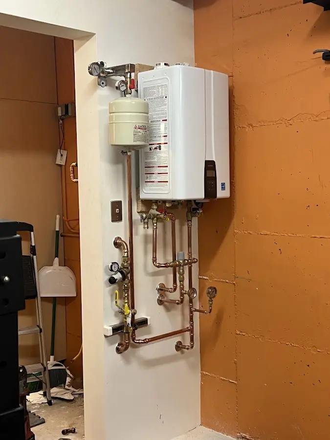 Plumbing technician inspecting water heater connections in North Middleton